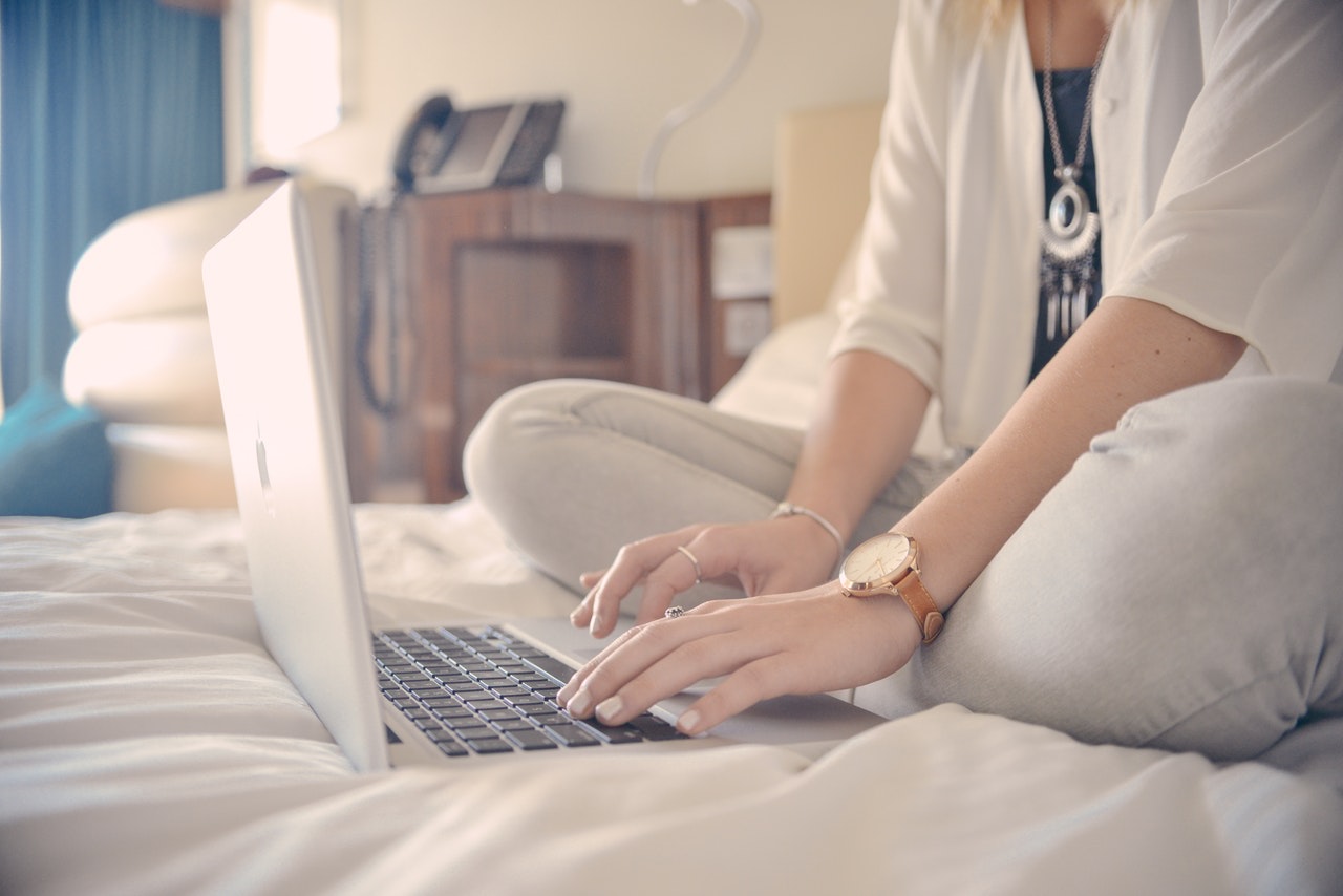 Liebeskummer Blog Frau sitzt alleine auf dem Bett mit Laptop